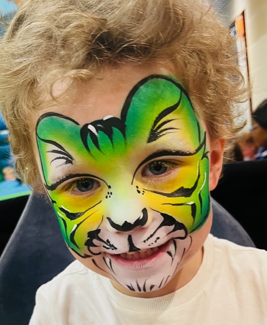 Boy with a green tiger face paint in Telford